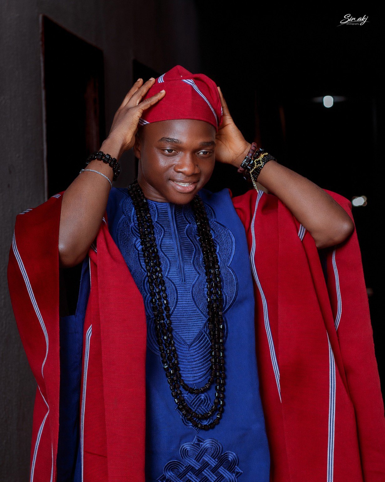 A young man wearing a bright red cap and blue outfit